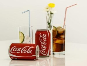 Coca-Cola cans with ice and lime on a table, fresh and invigorating.